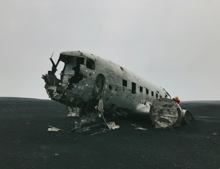 a propeller airplane sitting on top of a black beach