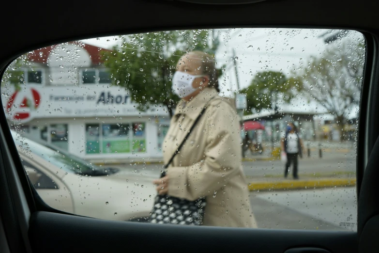 there is a woman in the back seat of the car as it looks like she's going out of the rain