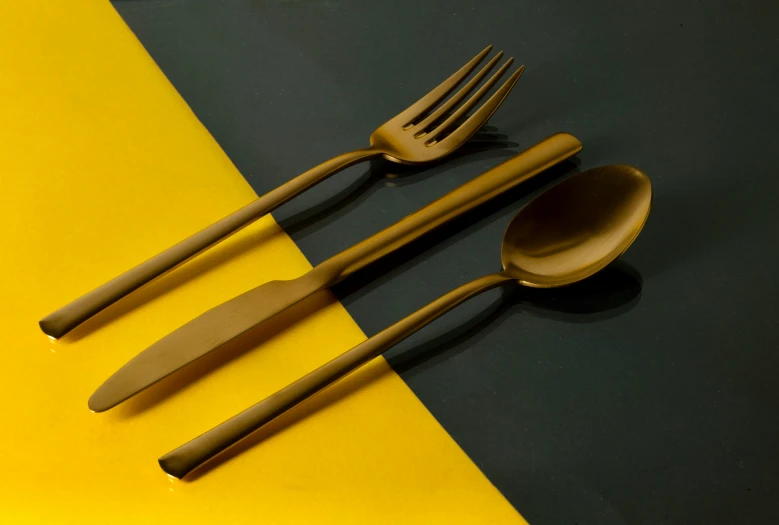 wooden spoons and fork on yellow, green, and blue table