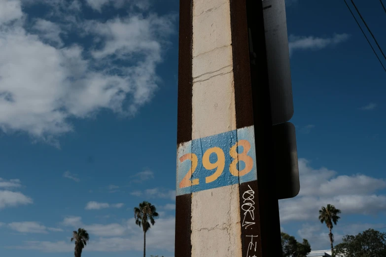 a blue sky and some palm trees and a street sign