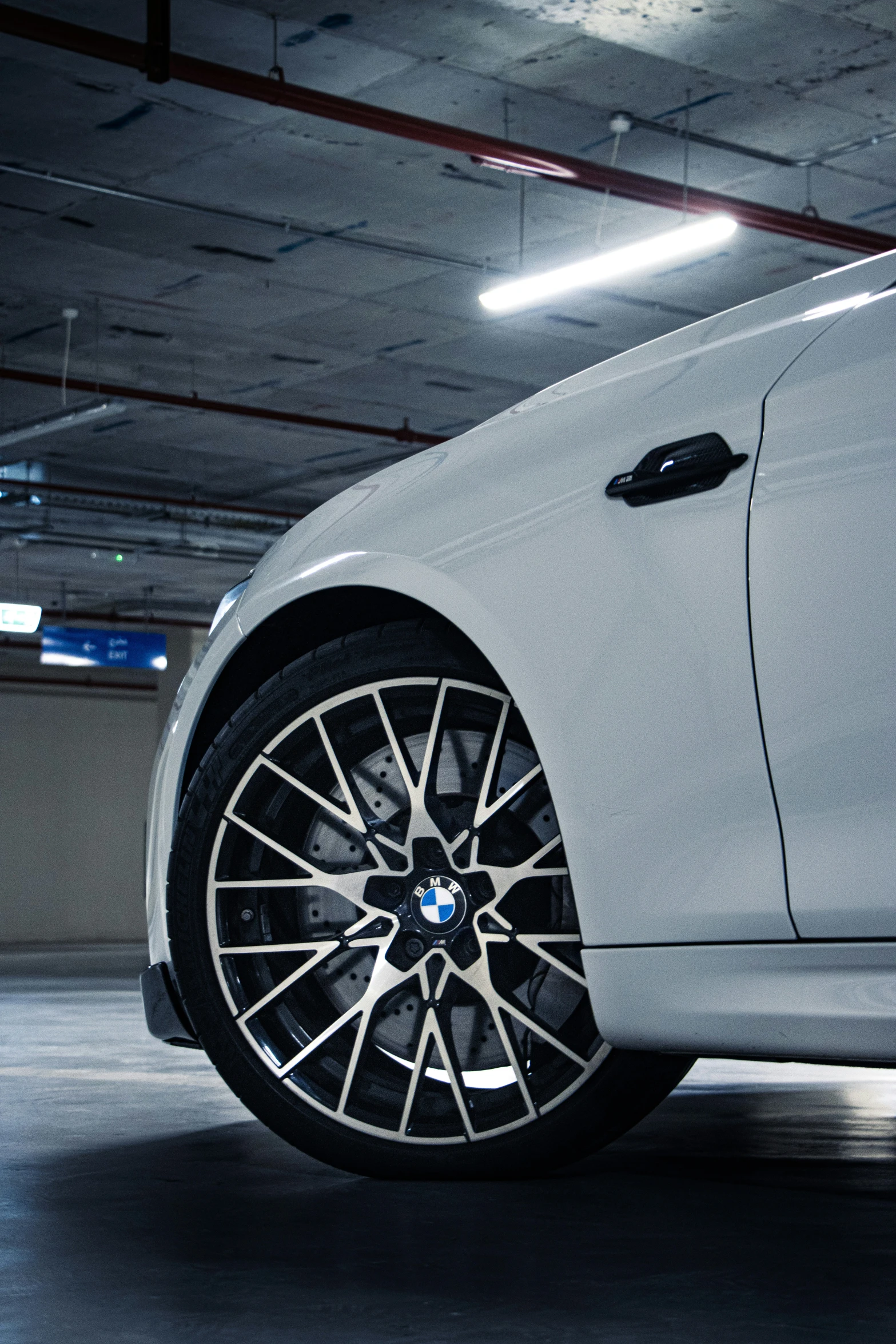 a white car parked in a garage under a light