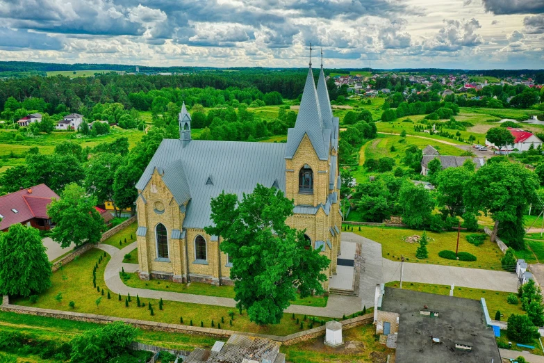 an aerial view of a cathedral surrounded by greenery and lush green countryside