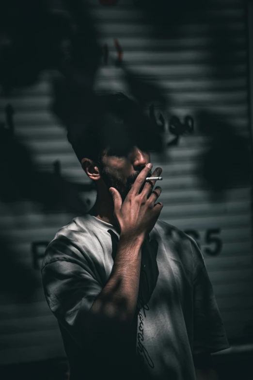 a man smoking his cigarette next to a large garage door