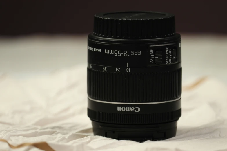 a camera lens sitting on top of a white sheet