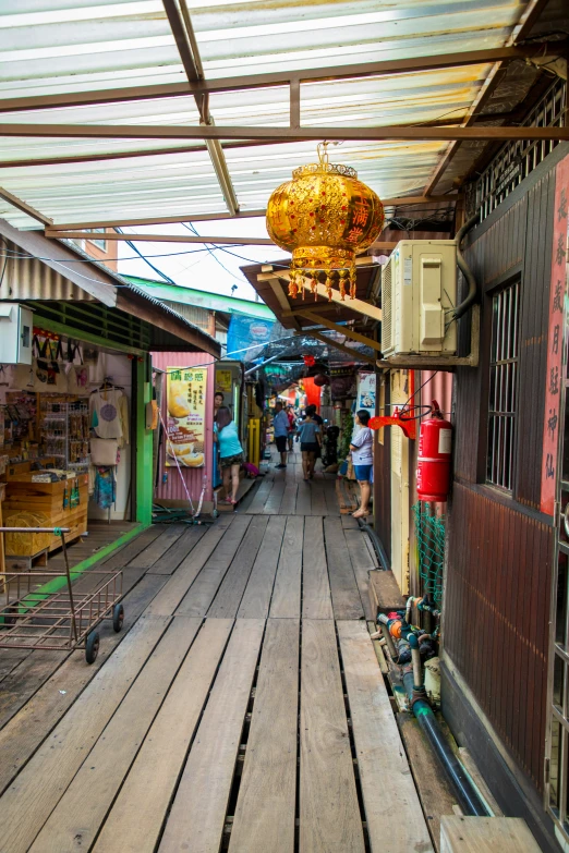 a sidewalk that has wooden benches, some with signs and a lamp