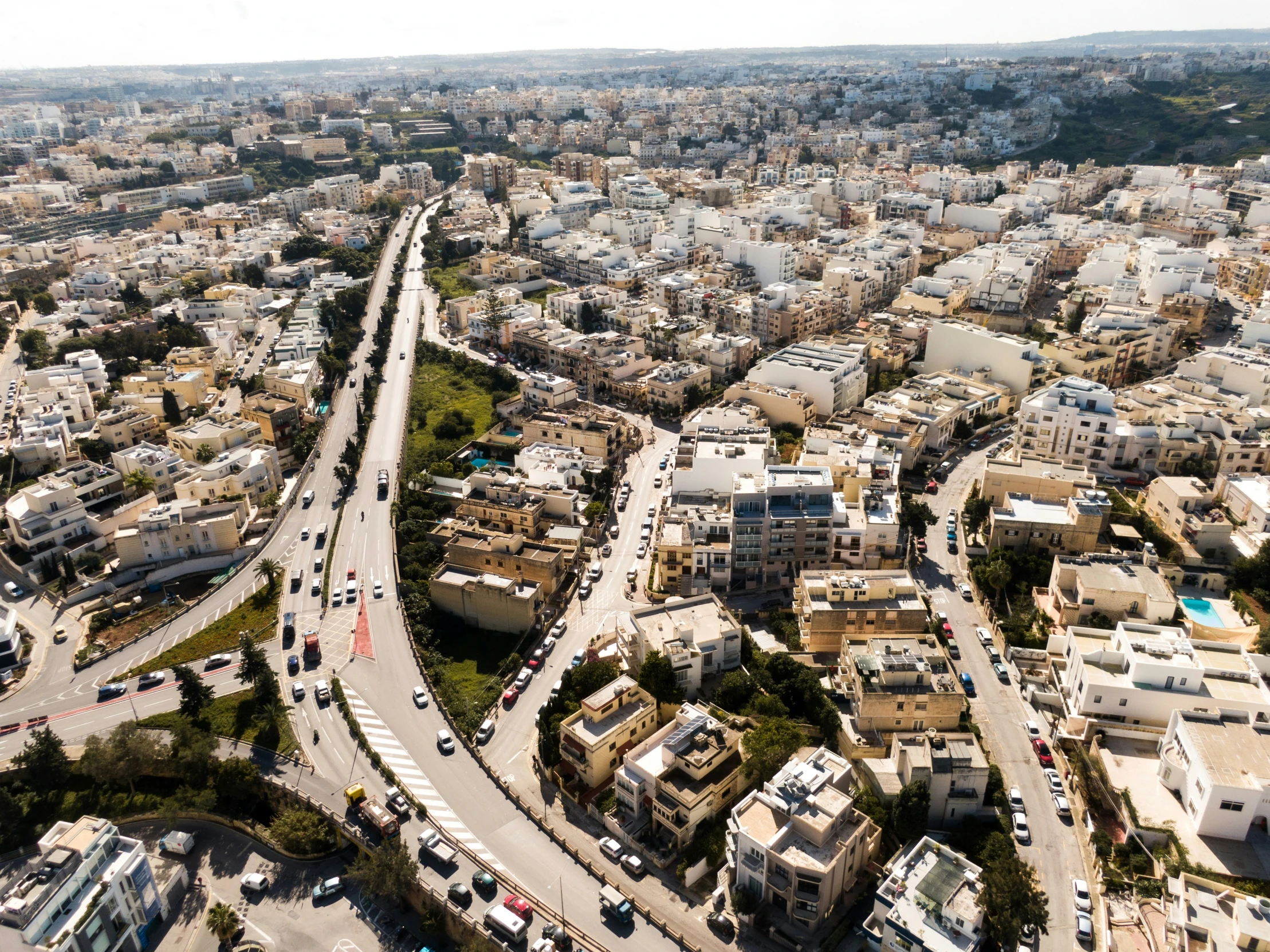 a busy road intersection in a city with buildings and lots of traffic