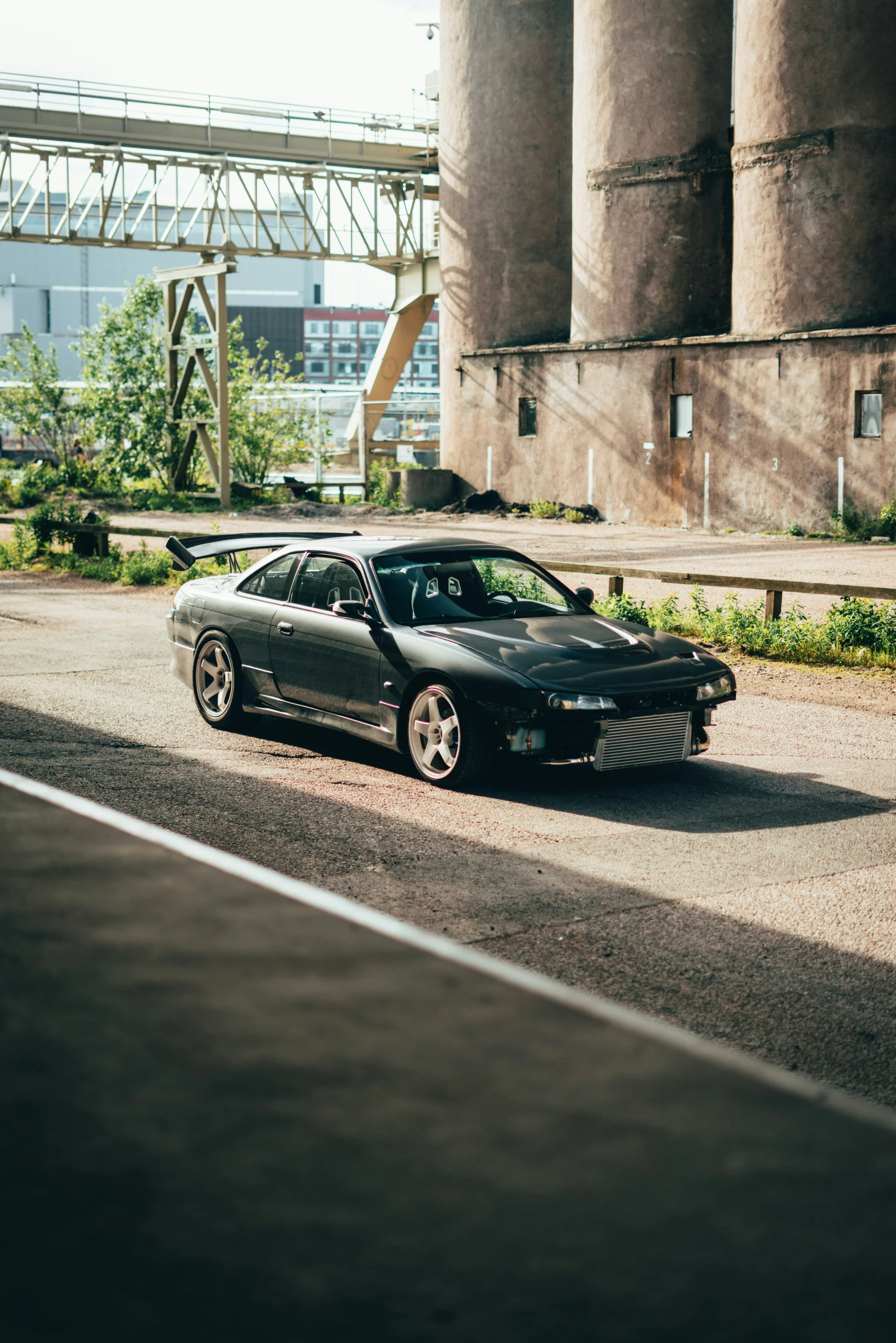 the black car is parked next to some buildings