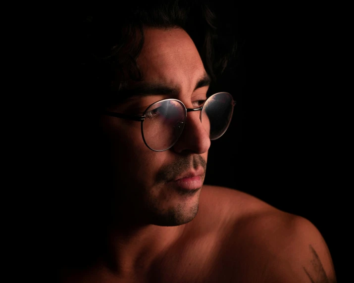 man in sunglasses in dark corner in front of camera