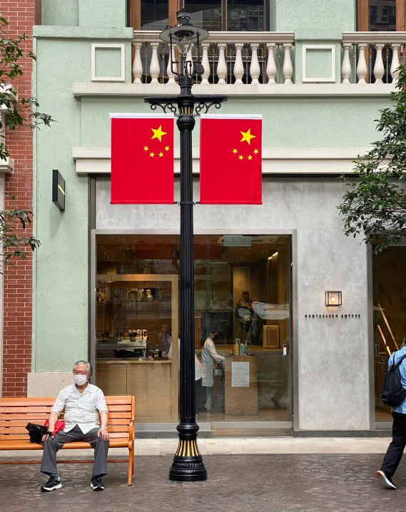 two people sitting on a bench in front of a building