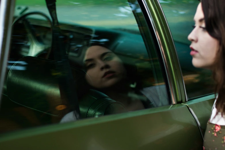 a lady in the back seat of a car with a person in the front