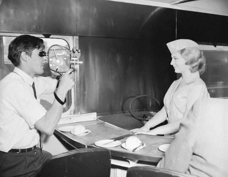 a man and woman in uniform sit at a table talking