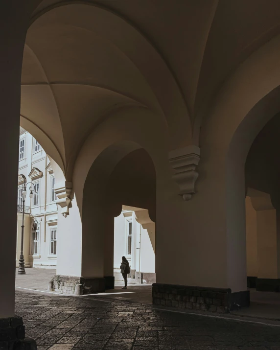 a person stands alone in an archway