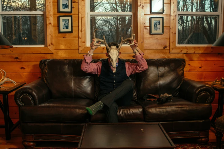 man wearing a deer mask on sitting on a couch