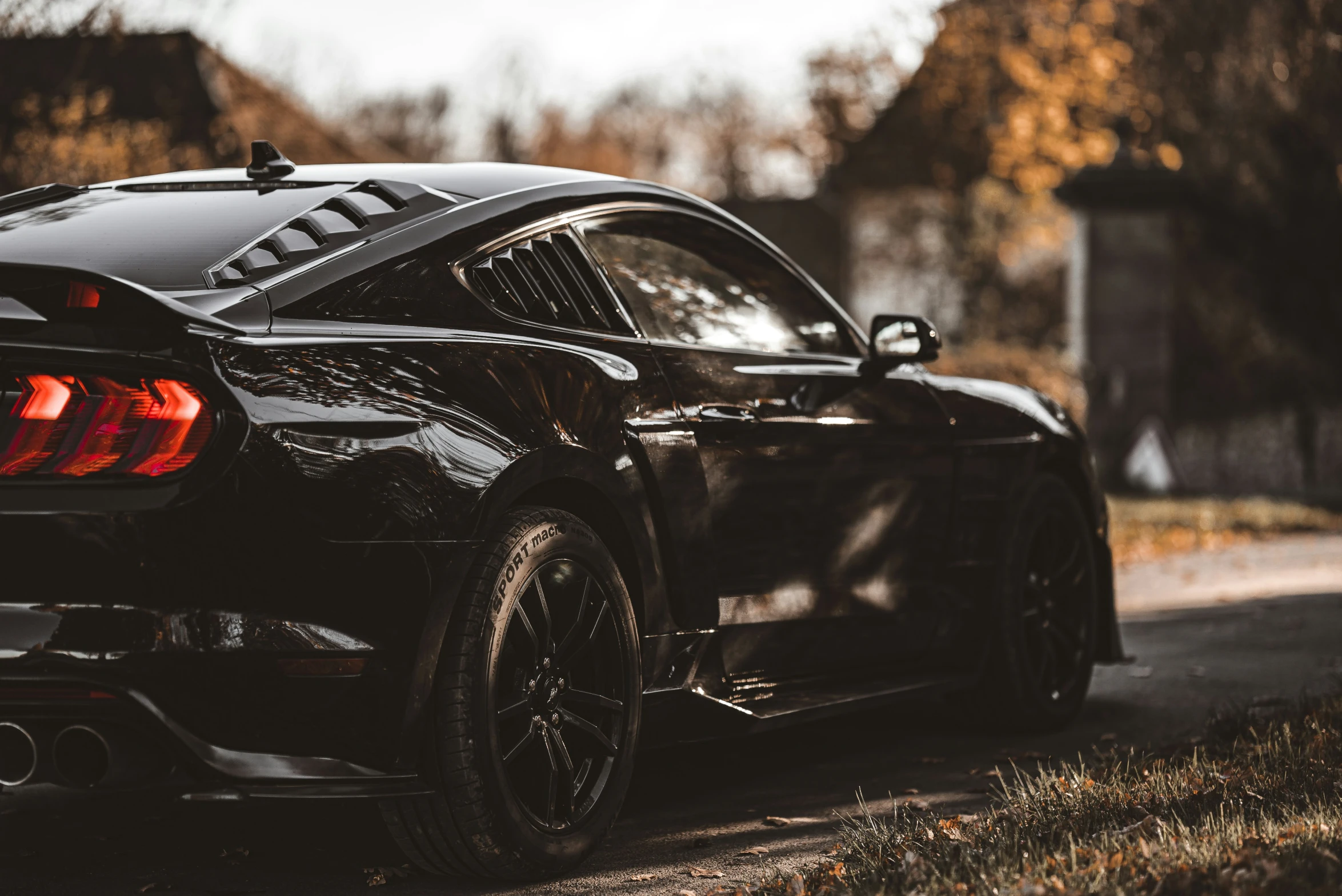 the black sports car is parked on the side of a road