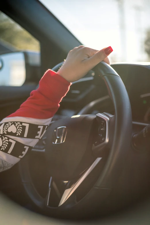 a person's hands on the steering wheel of a vehicle