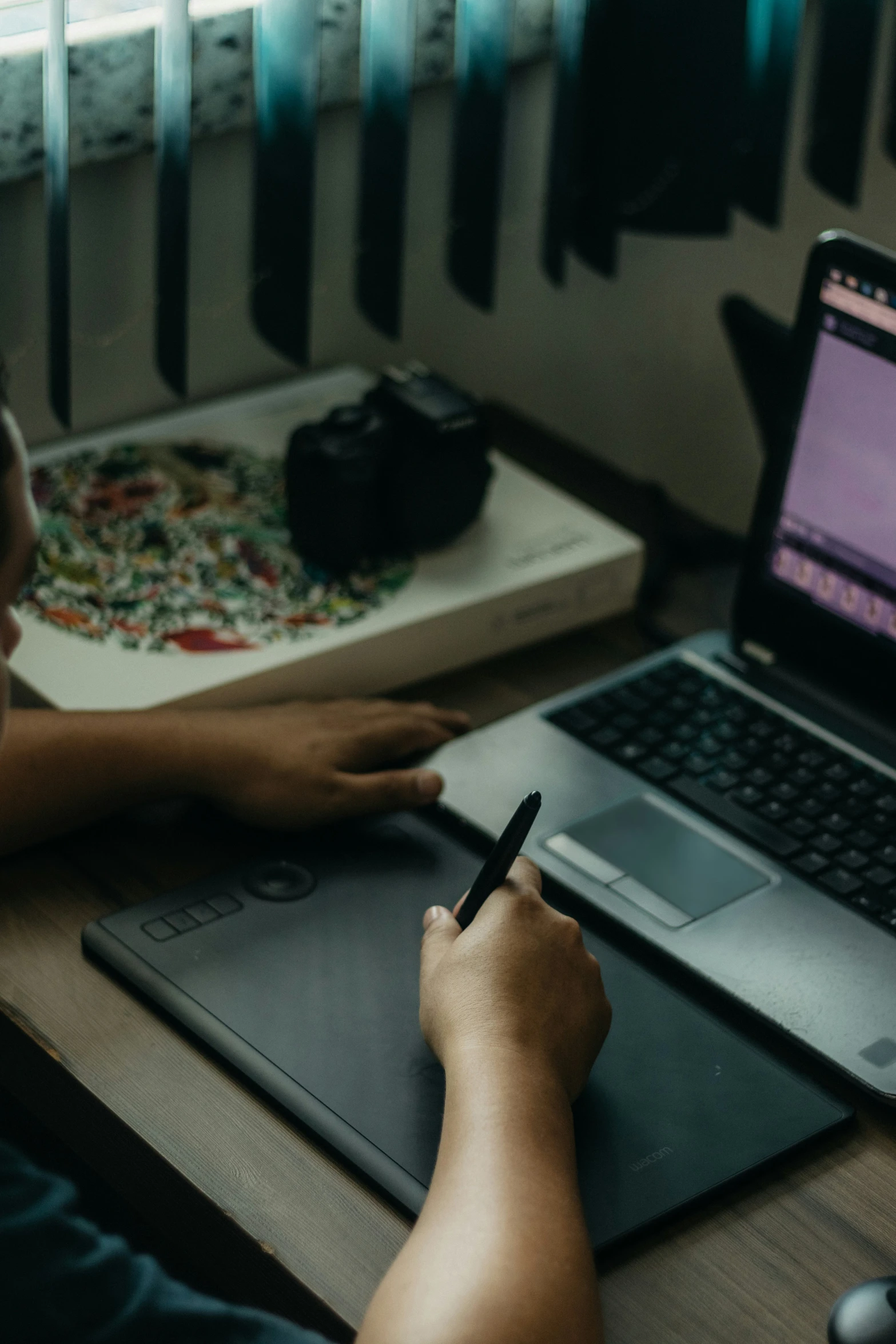 a person sitting at a desk with a laptop and notebook