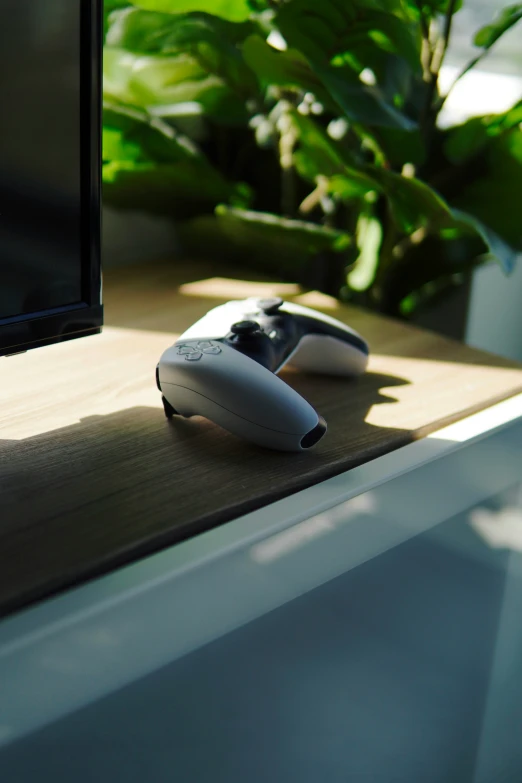 two computer monitors are on a table beside one another