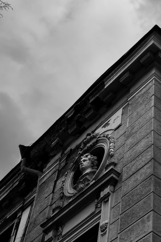 black and white pograph of a statue on the side of a building