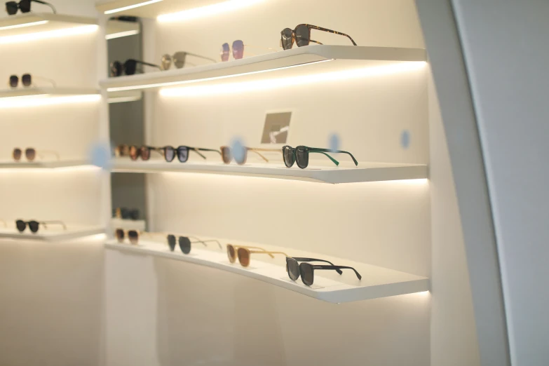 many different pairs of sunglasses are seen on shelves