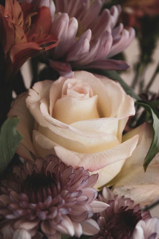 a bouquet of purple and white flowers on top of a table