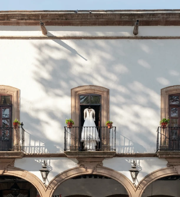 a white building with two large windows and a couple of brides standing in the door