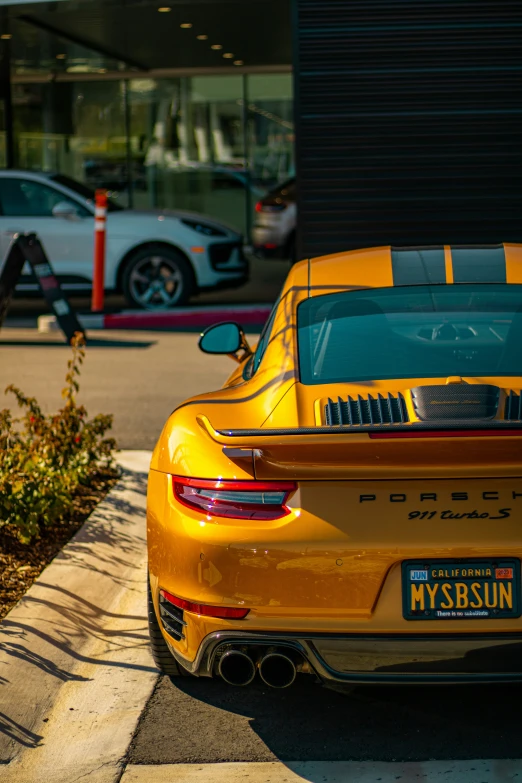 the rear view of a yellow porsche sports car