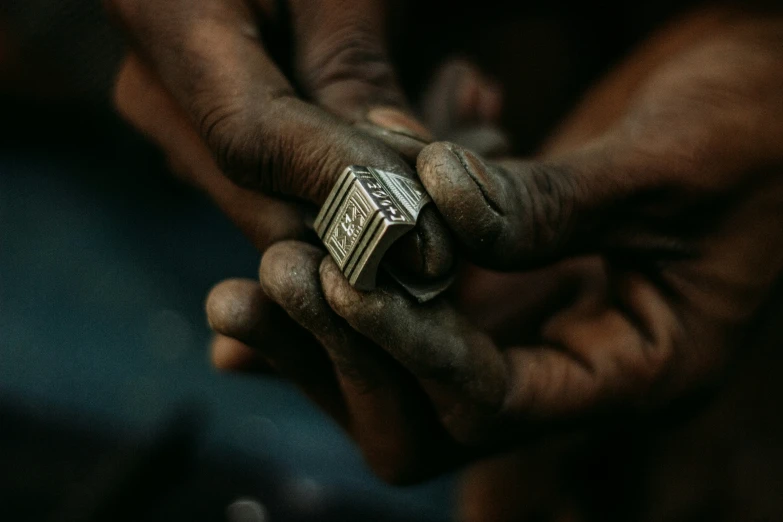 hands holding soing while they are wearing a ring