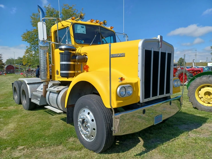 a yellow truck parked on a green grass field