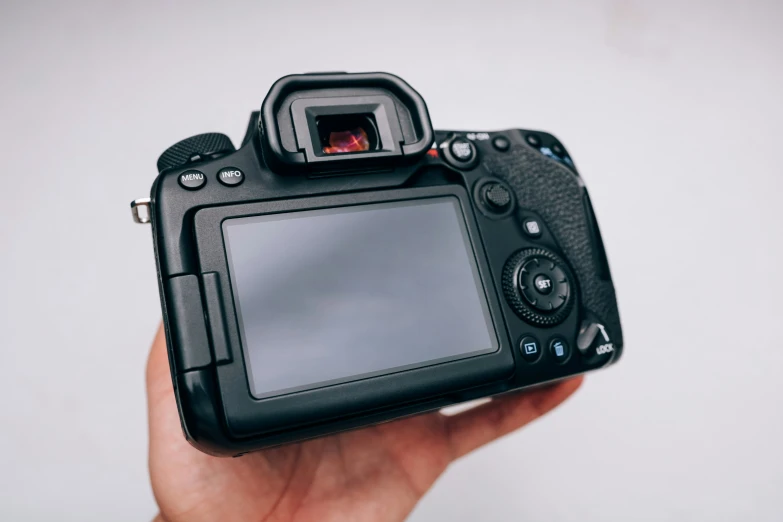 a black camera sitting in someones hand