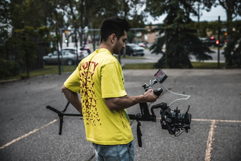 a man standing in a parking lot holding onto a camera rig