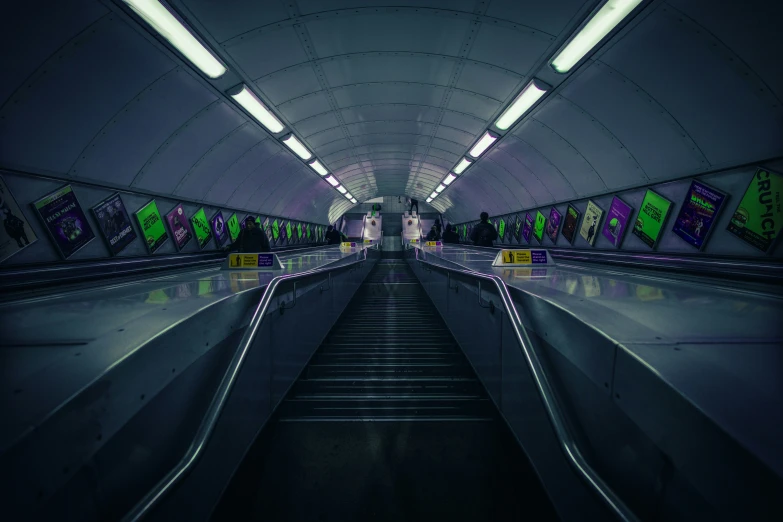 a dimly lit subway station with escalators