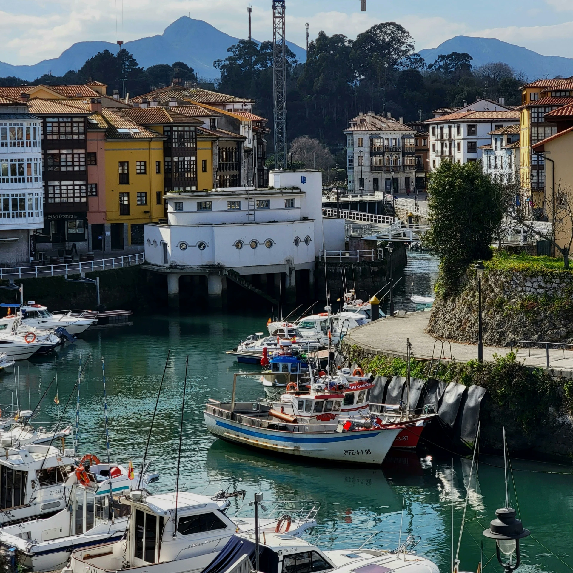 boats are parked in a small bay next to a bridge