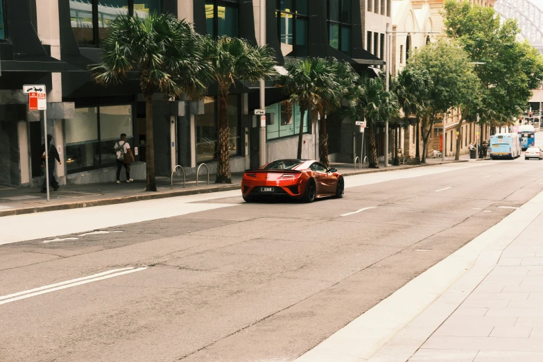 the car is sitting outside of a tall building