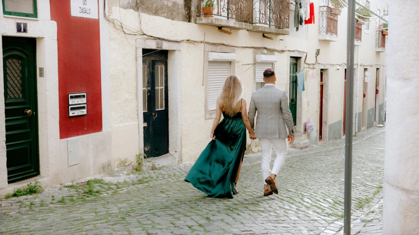 a couple is walking down an alley way