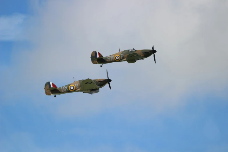 two fighter planes flying together in the sky