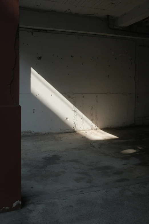 an empty building with a white wall and red door