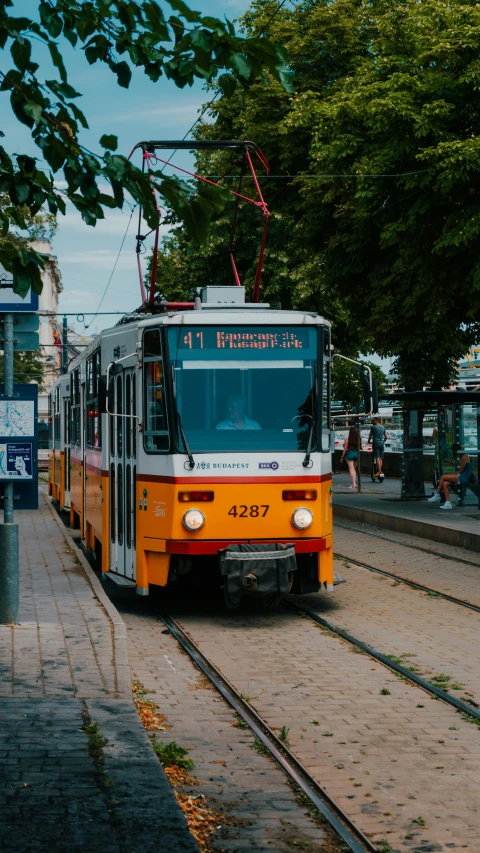 a public transit trolley is stopped at the bus stop