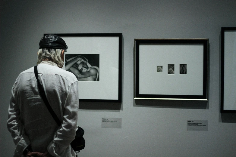 there is a person standing next to framed pictures