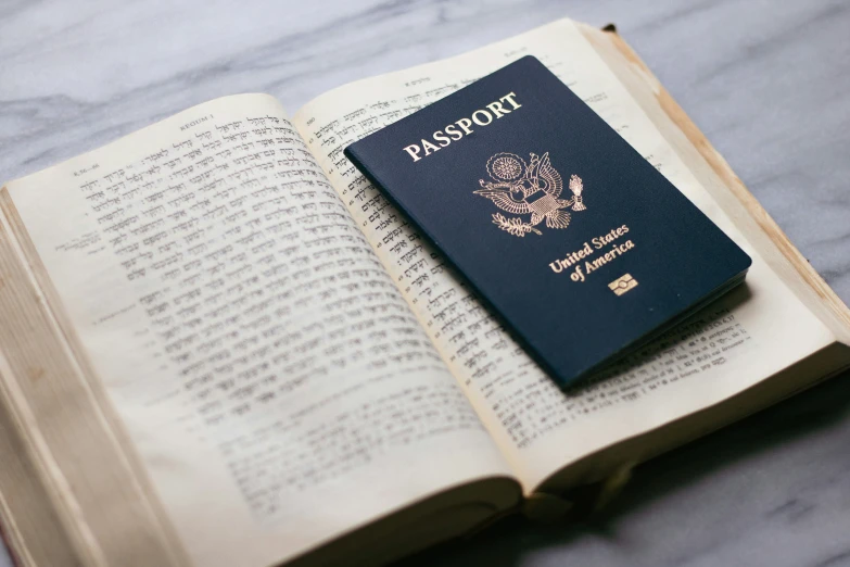 a passport is lying on top of an open book