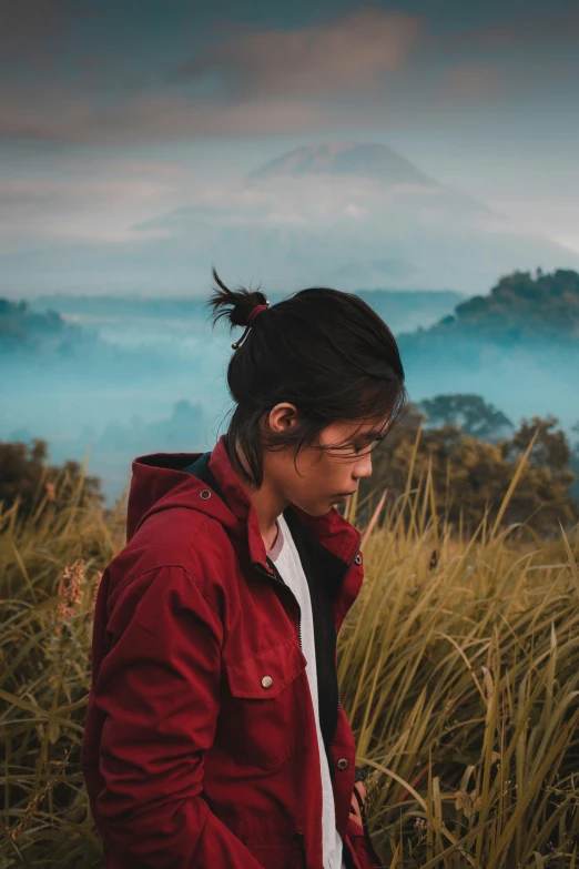 woman in field looking down at laptop screen