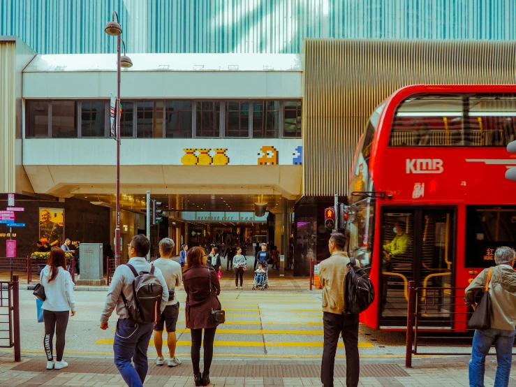 the city bus is riding past people at the crosswalk