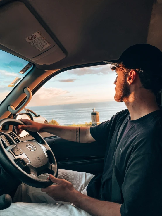 a man sitting at the wheel of a car with a dashboard and steering wheel