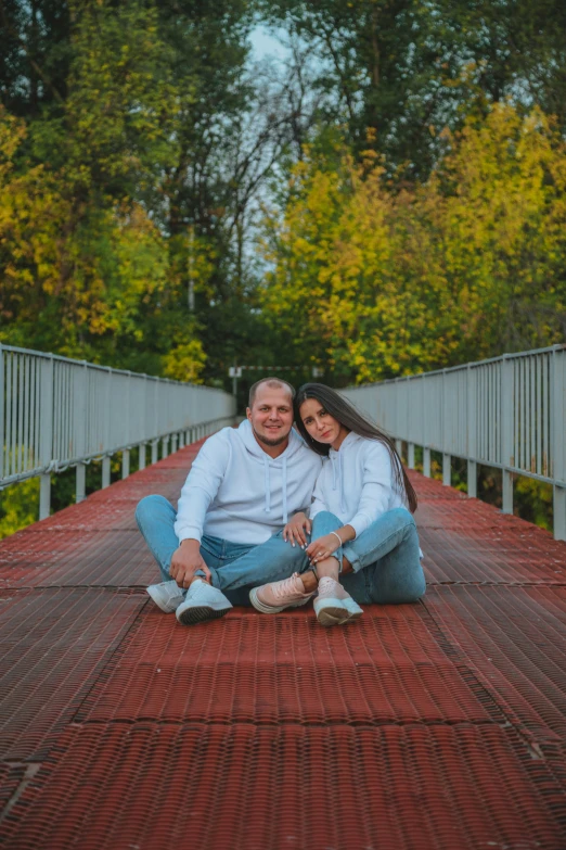 a man and woman sit on top of a red carpet