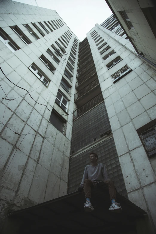 a man sitting on the ledge of a rooftop