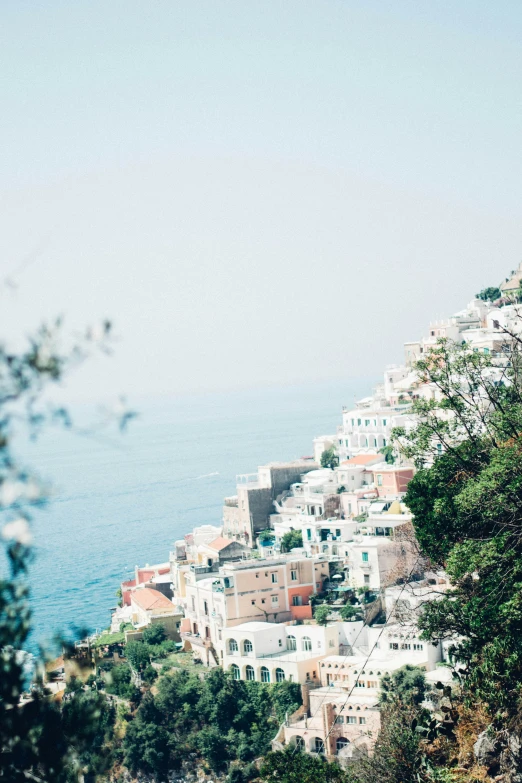 a bird is flying above a white city by the ocean