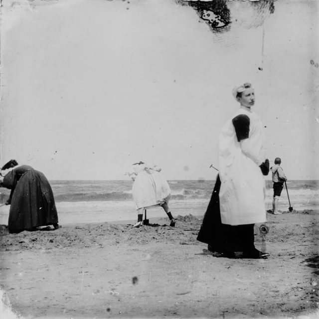 vintage pograph of women on beach near man flying kite
