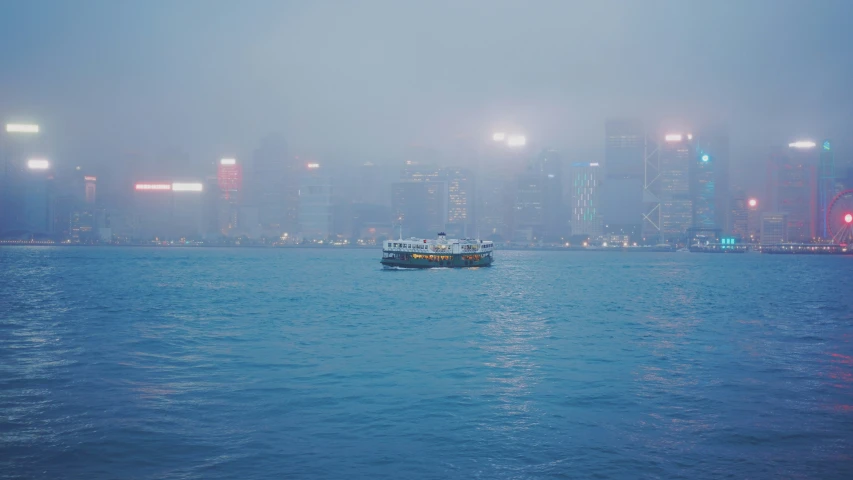 a small boat is sailing on the ocean near the city