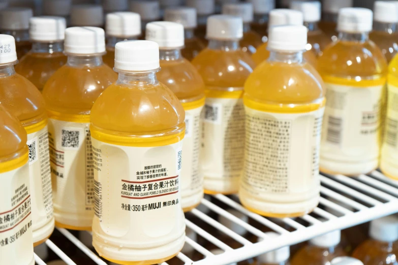 plastic bottles of orange liquid sitting on a shelf