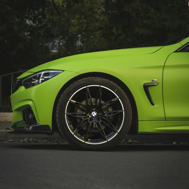 an electric green sports car parked next to a curb