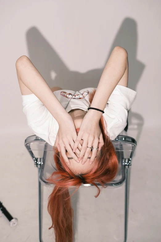 a girl with red hair is laying down on a chair
